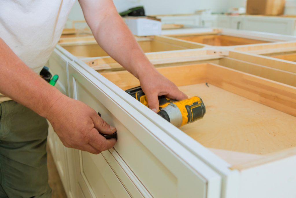 Installation of drawers handles on kitchen cabinets